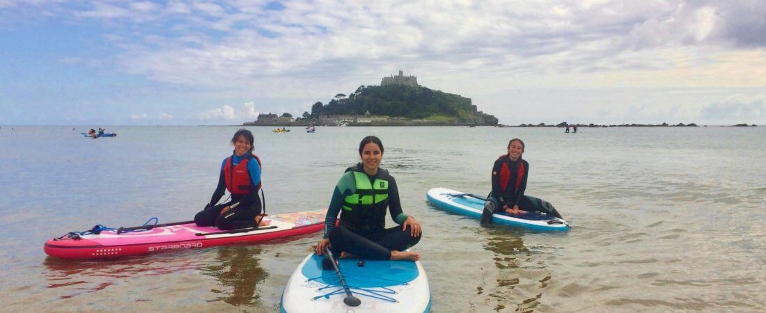 Students sitting on paddleboards at St Michael's Mount.