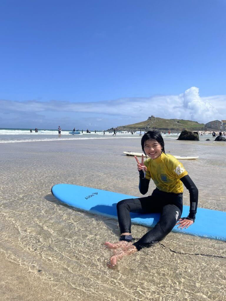 Junior Summer School student on a surfboard on Porthmeor beach, St Ives.