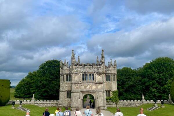 Adult students walking towards Lanhydrock's gatehouse.