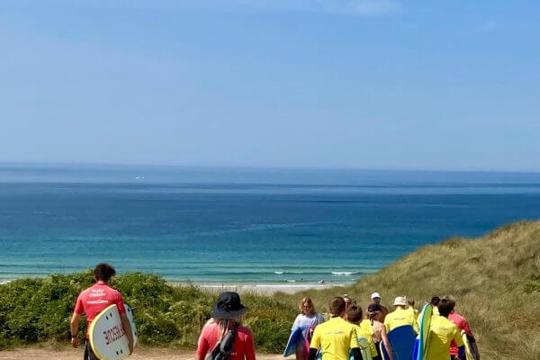 Language Tree students walking to Gwithian with surfboards.
