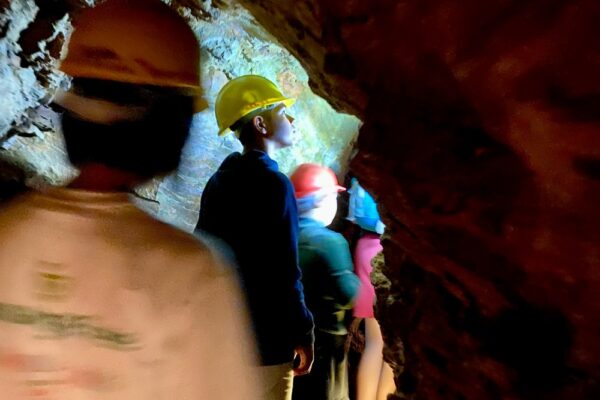 Students exploring an old tin mine tunnel in Cornwall